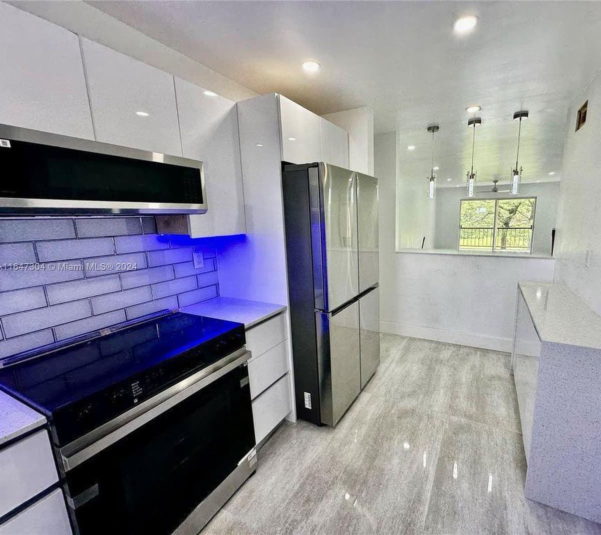 Modern kitchen remodel with tiled floors, subway tile backsplash, and white cabinetry